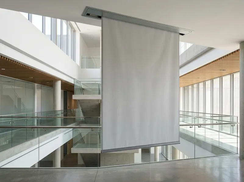 Rookwerend scherm BACHSMOKE DA gedeeltelijk afgedaald uit een plafondcassette in een atrium